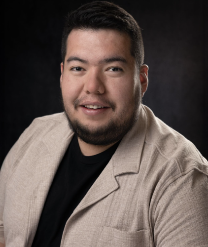 Ismael in a tan suit jacket and black shirt